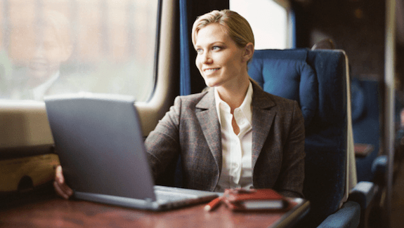 Žena se smiješi dok radite vlak poslovna putovanja