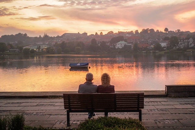 A couple sitting by lake Como lake