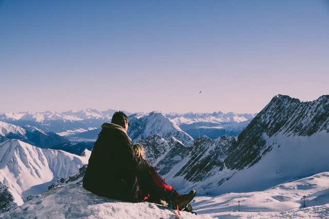 A Couple Sitting On Snowy French Alps
